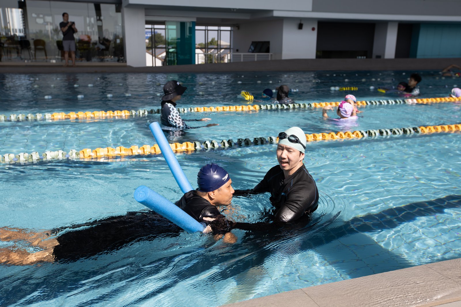 ผู้เข้าอบรมฝึกสอนการลอยตัวด้วยอุปกรณ์ · Trainee teacher practising a supported float drill