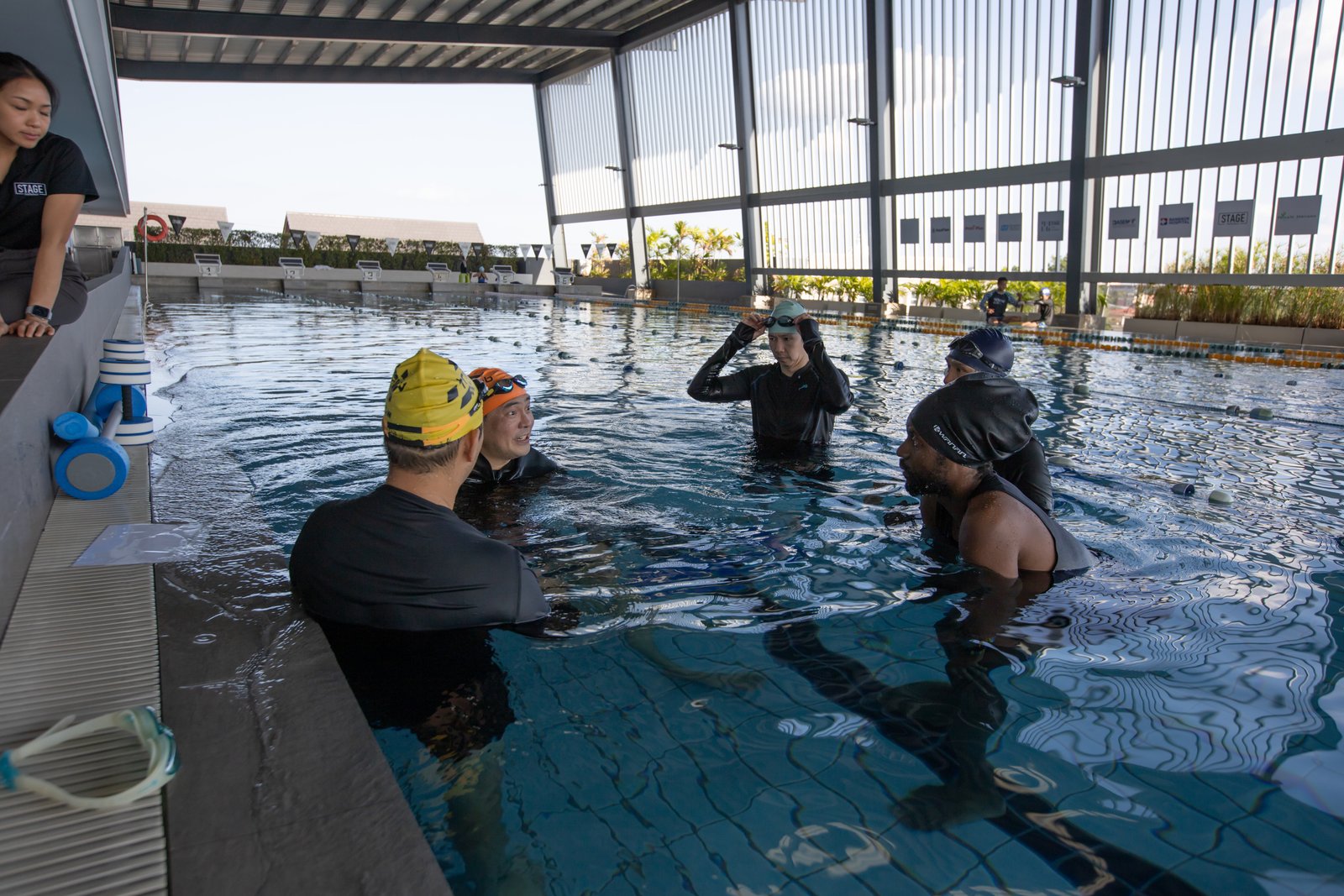 โค้ชบรีฟผู้เข้าอบรมจากขอบสระ · Coach briefing trainees from the pool edge